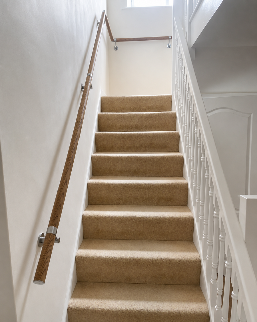 CoreMount oak wall mounted handrail installed on a carpeted staircase by a customer